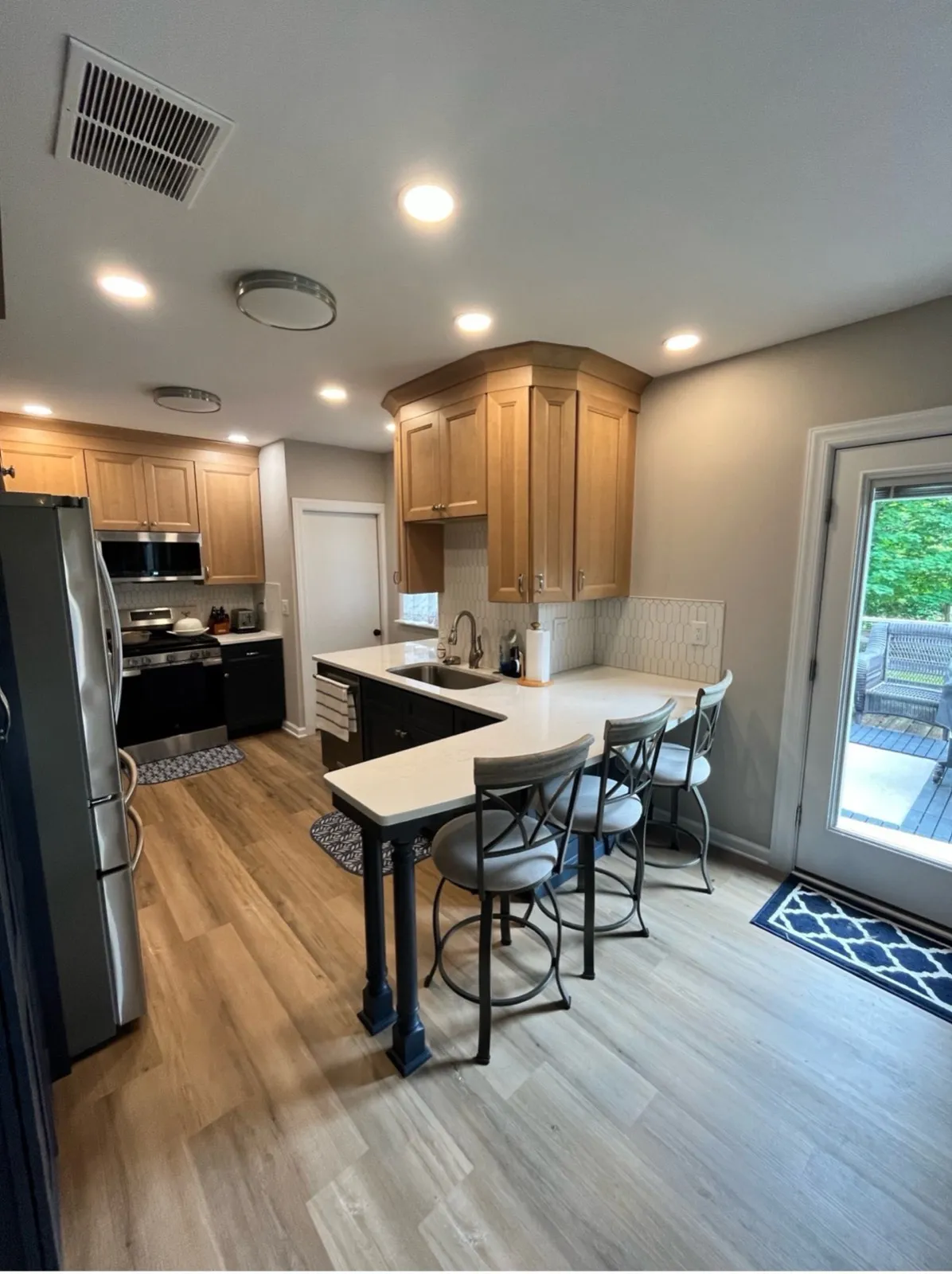 Kitchen with wood cabinets and a breakfast bar, by Kubat Construction
