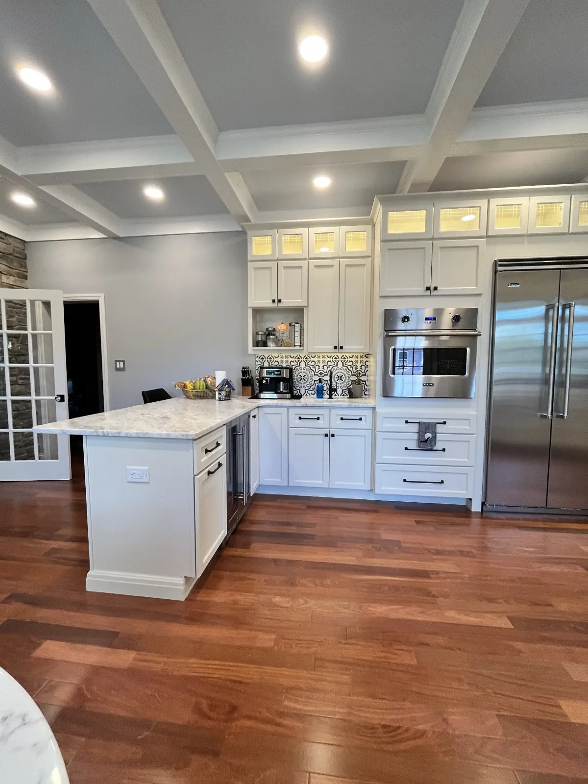 White kitchen with a coffered ceiling by Kubat Construction